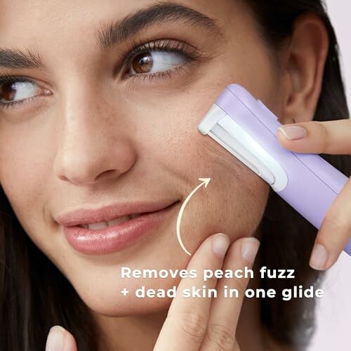 Woman using a facial razor to remove peach fuzz and dead skin.